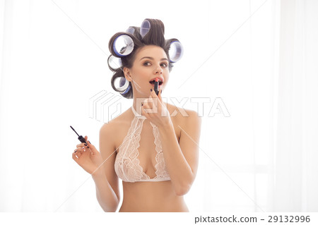 Woman applying make-up indoors 29132996