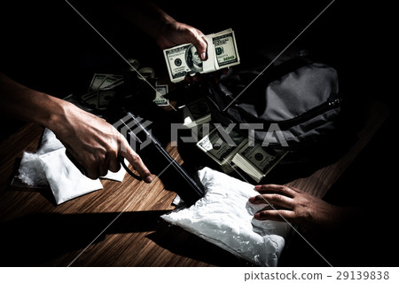 Drug dealer use gun to push the envelope on table  29139838