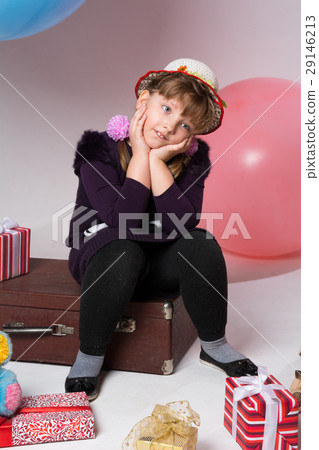 Thoughtful teenager in a hat sitting on a suitcase 29146213