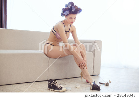 Woman dressing up in fishnet stockings indoors Woman dressing up in fishnet stockings indoors 29149345