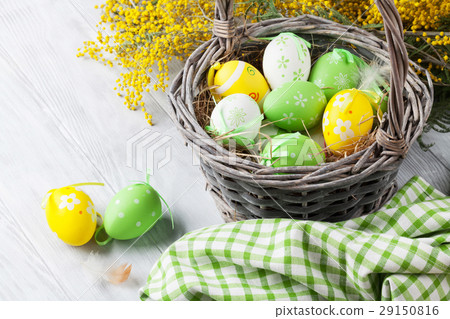 Colorful easter eggs in basket and mimosa Colorful easter eggs in basket and mimosa 29150816