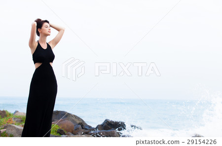 beautiful young woman standing on the stone coast beautiful young woman standing on the stone coast 29154226