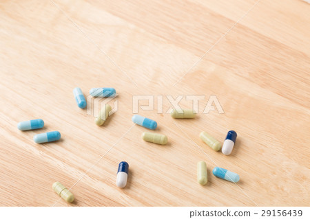 Scattered medicine green and blue capsules 29156439