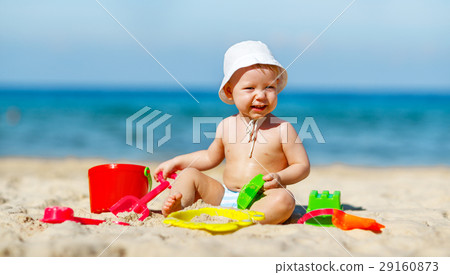 baby boy playing with toys and sand on beach 29160873