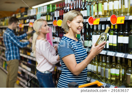 Smiling mature woman at wine section 29163637