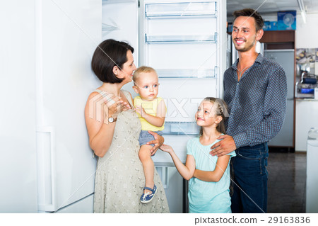 family choosing new freezer in store . family choosing new freezer in store . 29163836