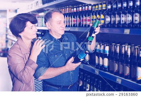 Portrait of an elderly couple buying a beer at the grocery store 29163860