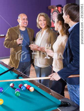 Adults with wine at billiard table. 29163961