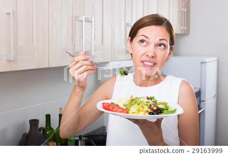 cheerful woman eating salad 29163999