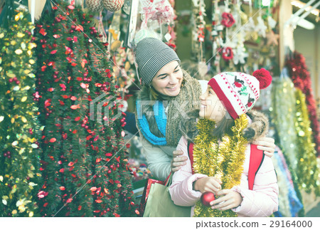 Happy mother with smiling little daughter buying decorations for Xmas 29164000