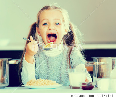 Hungry little girl with milk and oatmeal kasha 29164121