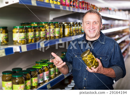 Man selecting cucumbers at store Man selecting cucumbers at store 29164194