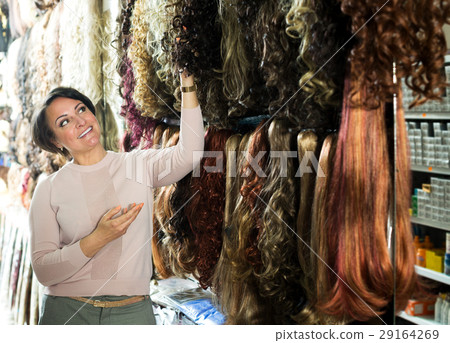 Smiling female customer selecting clip-in hair Smiling female customer selecting clip-in hair 29164269