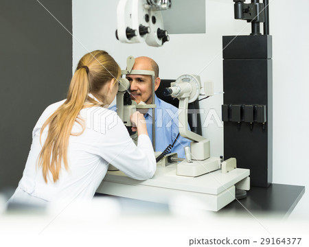 female ophthalmologist and mature patient checking eyesight in clinic female ophthalmologist and mature patient checking eyesight in clinic 29164377