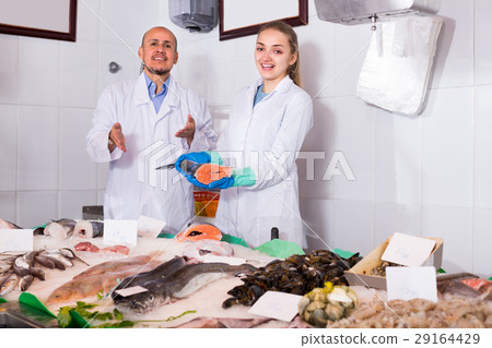 Sellers near display with cooled fish. 29164429