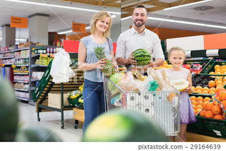 Man and woman with girl choosing fruits 29164639