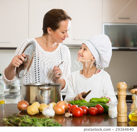 Smiling girl and mom at kitchen Smiling girl and mom at kitchen 29164640