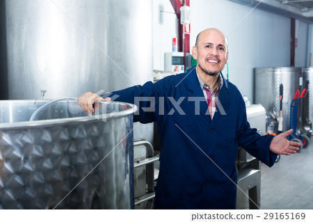 mature man working in wine fermentation section. 29165169