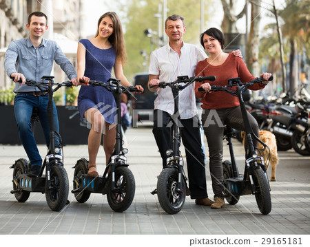Adults traveling through city by bicycles. 29165181
