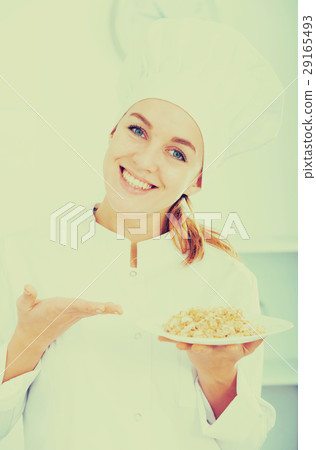 girl in hat and white coat showing porridge girl in hat and white coat showing porridge 29165493