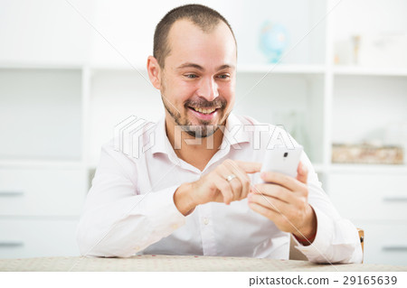 Positive young man with smartphone Positive young man with smartphone 29165639
