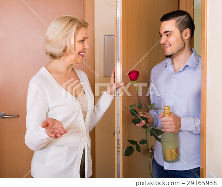 Mature woman and young guy at doorway. Mature woman and young guy at doorway. 29165938
