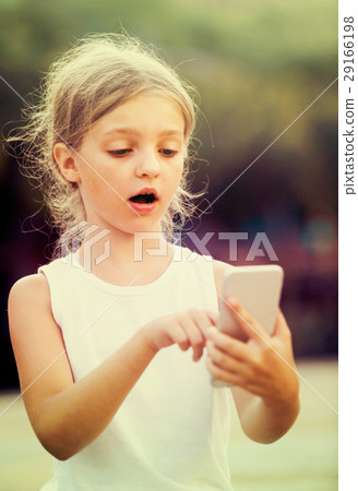 girl surprised looking at phone 29166198