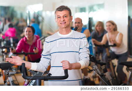 Elderly man on fitness cycle in fitness club. 29166333