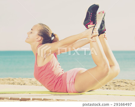 Positive young sporty woman exercising Positive young sporty woman exercising 29166497