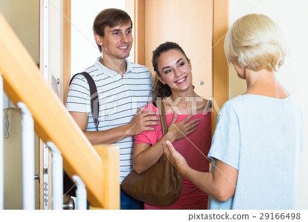 Cheerful senior woman greeting adult children coming with visit Cheerful senior woman greeting adult children coming with visit 29166498