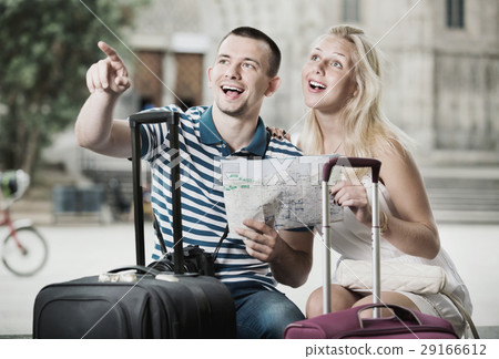 Young happy man and woman tourists having map Young happy man and woman tourists having map 29166612