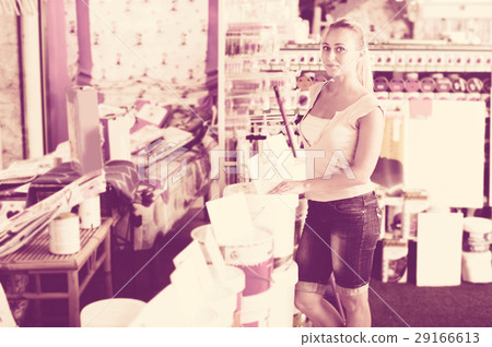 female customer choosing paint can 29166613
