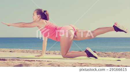 Positive sporty woman exercising yoga 29166615
