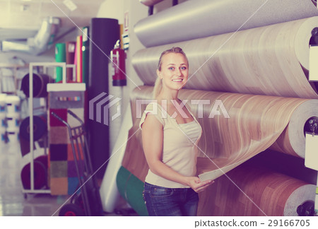 cheerful woman customer choosing linoleum flooring in hypermarket 29166705
