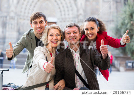 Close up of tourists posing on city street. 29166784