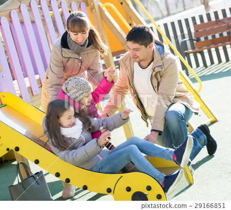 Happy family spending time at children slide Happy family spending time at children slide 29166851