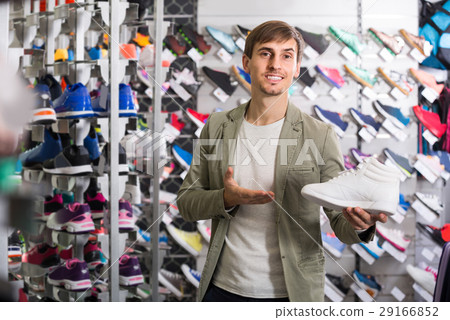 young man showing shoes in the sport store young man showing shoes in the sport store 29166852