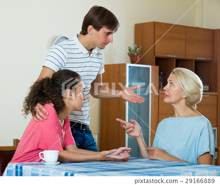 Adult kids demanding something of mature mother indoors 29166889