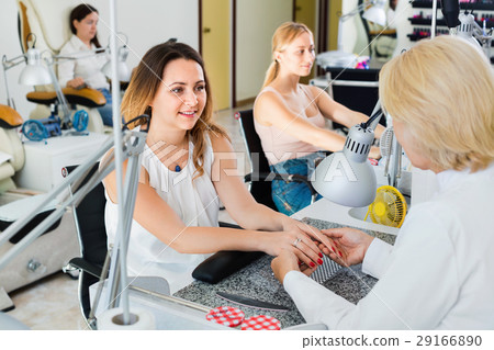 Two women clients having manicure done in nail salon Two women clients having manicure done in nail salon 29166890