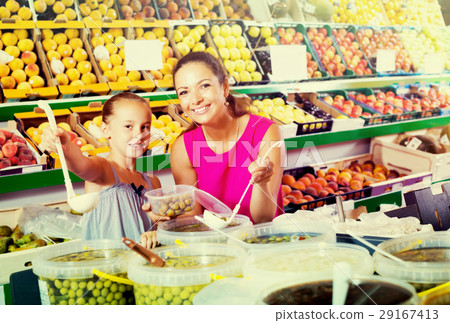 Woman with girl buying pickled olives 29167413