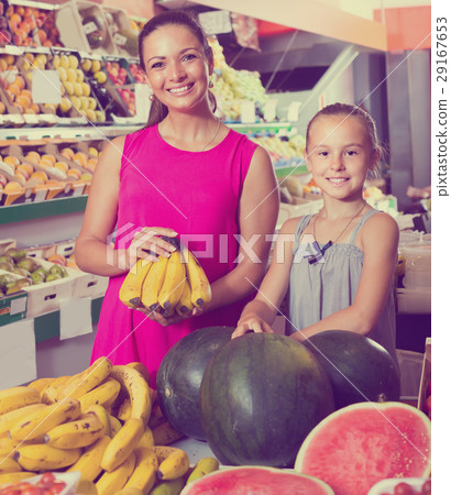 mother with girl picking bananas on market . mother with girl picking bananas on market . 29167653