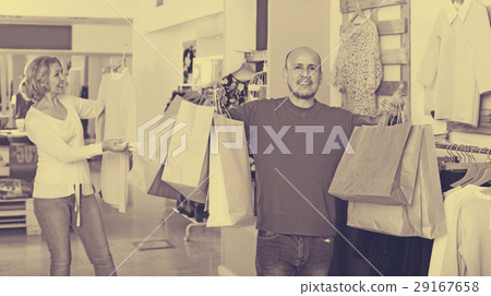 Man with bags waiting for woman selecting dress Man with bags waiting for woman selecting dress 29167658