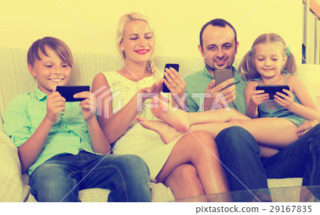Portrait of family playing with gadgets at home 29167835