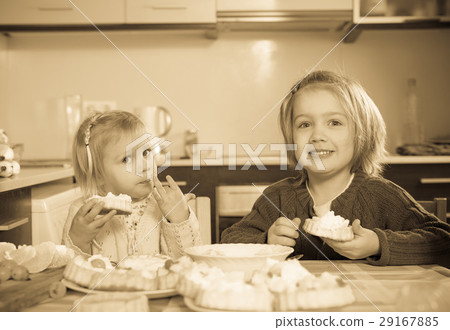 Children eat cakes at kitchen 29167885