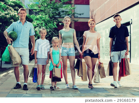 Man and woman with four kids walking and holding shopping bags Man and woman with four kids walking and holding shopping bags 29168179