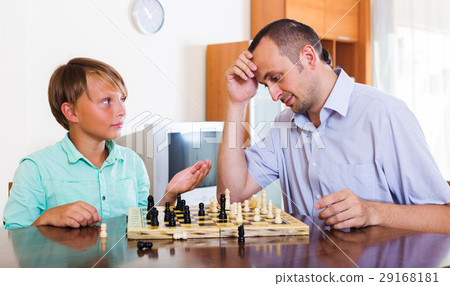 Father and son playing chess at home 29168181