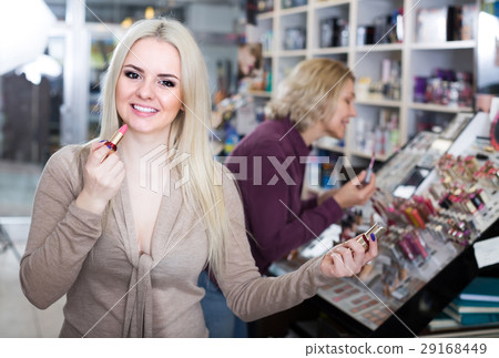 mother and daughter choosing lipstick on display and smiling mother and daughter choosing lipstick on display and smiling 29168449