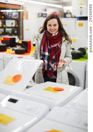 Positive female customer looking at dryers 29168489