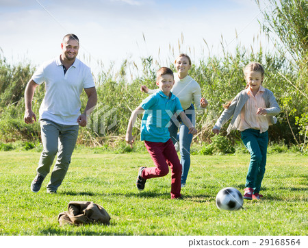 Young parents with two kids playing soccer 29168564