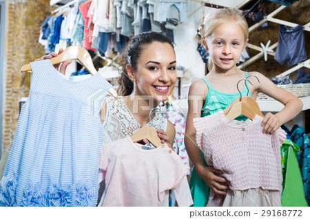 Happy family choosing clothes in kids apparel boutique Happy family choosing clothes in kids apparel boutique 29168772